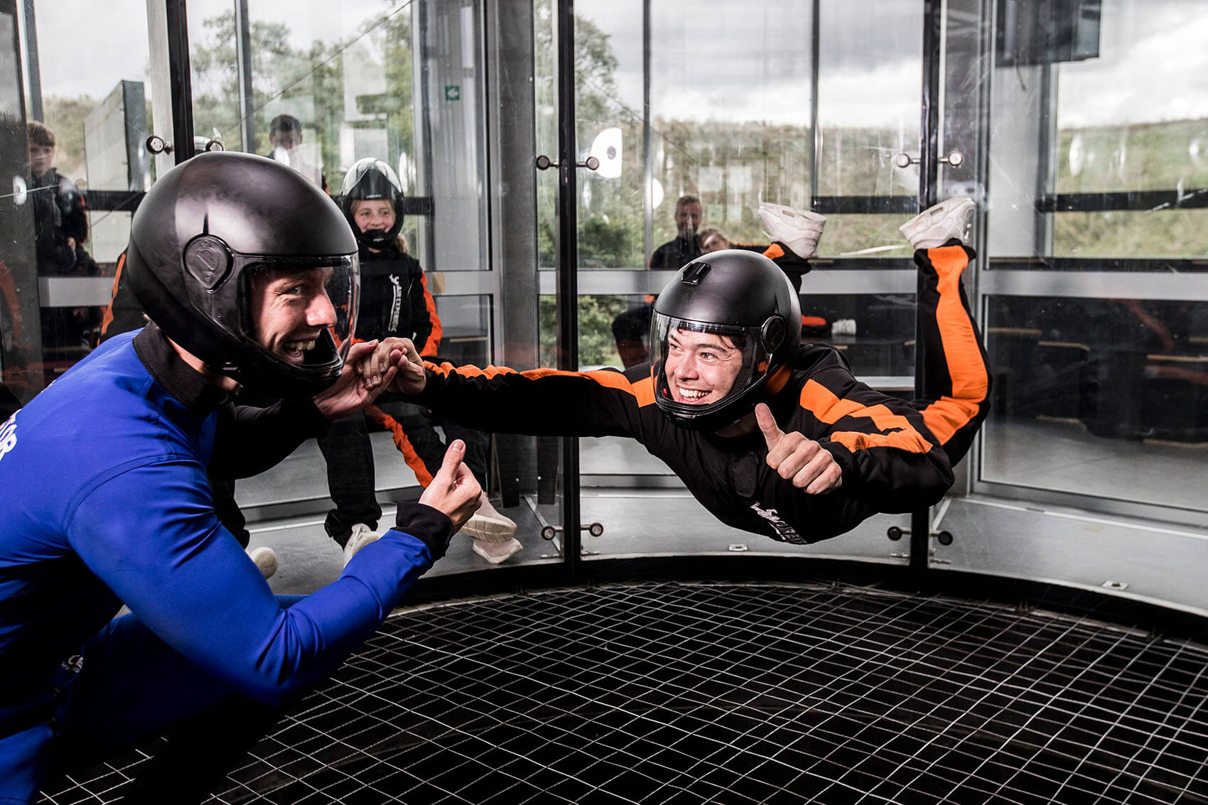 Man flying in windtunnel with instructor